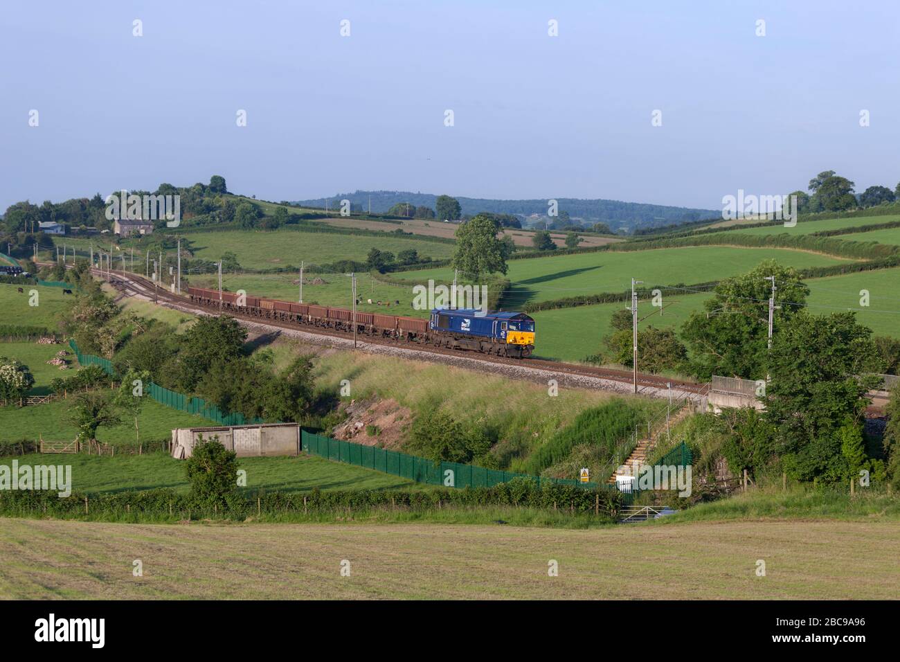 Direct Rail Services class 66 locomotive 66302 on the west coast mainline in Cumbria with a freight train carrying materials for Network Rail Stock Photo