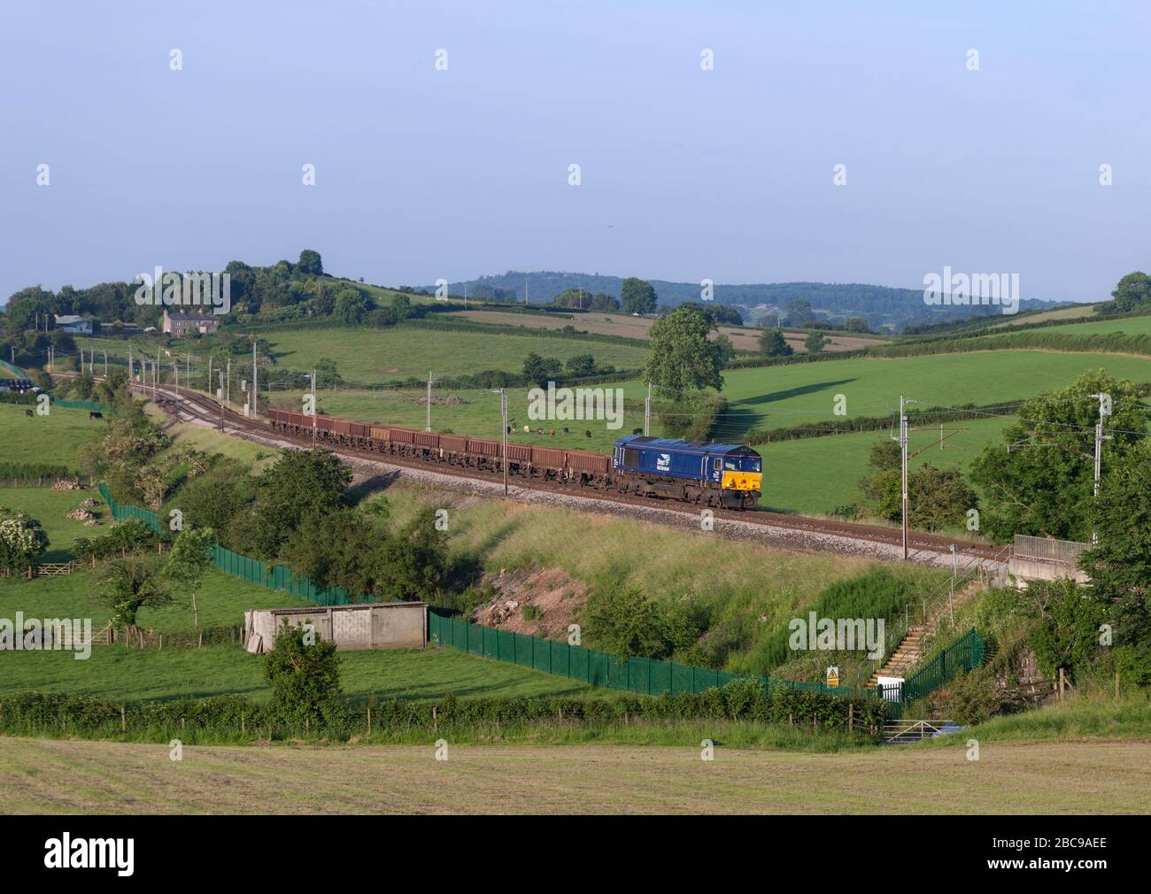 Direct Rail Services class 66 locomotive 66302 on the west coast mainline in Cumbria with a freight train carrying materials for Network Rail Stock Photo