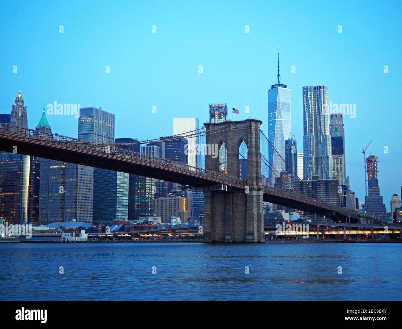 One World Trade Center, Freedom Tower and Brooklyn Bridge at dawn, seen from the East River, Manhattan, New York, USA Stock Photo