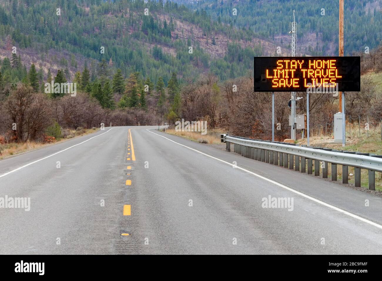 Toppenish, WA / USA - March 28, 2020: Electronic sign along U.S. Highway 97 notifying people to stay home and save lives by reducing the risk of being Stock Photo