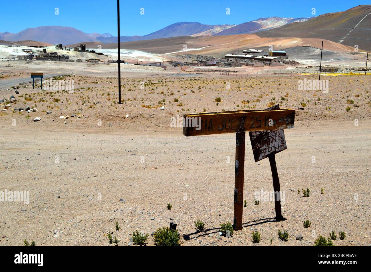 Overview of the La Casualidad mine, with a sign in the foreground of the detour to the Julia mine. The sign says: 'Julia mine 25 km'. Salta, Argentina Stock Photo