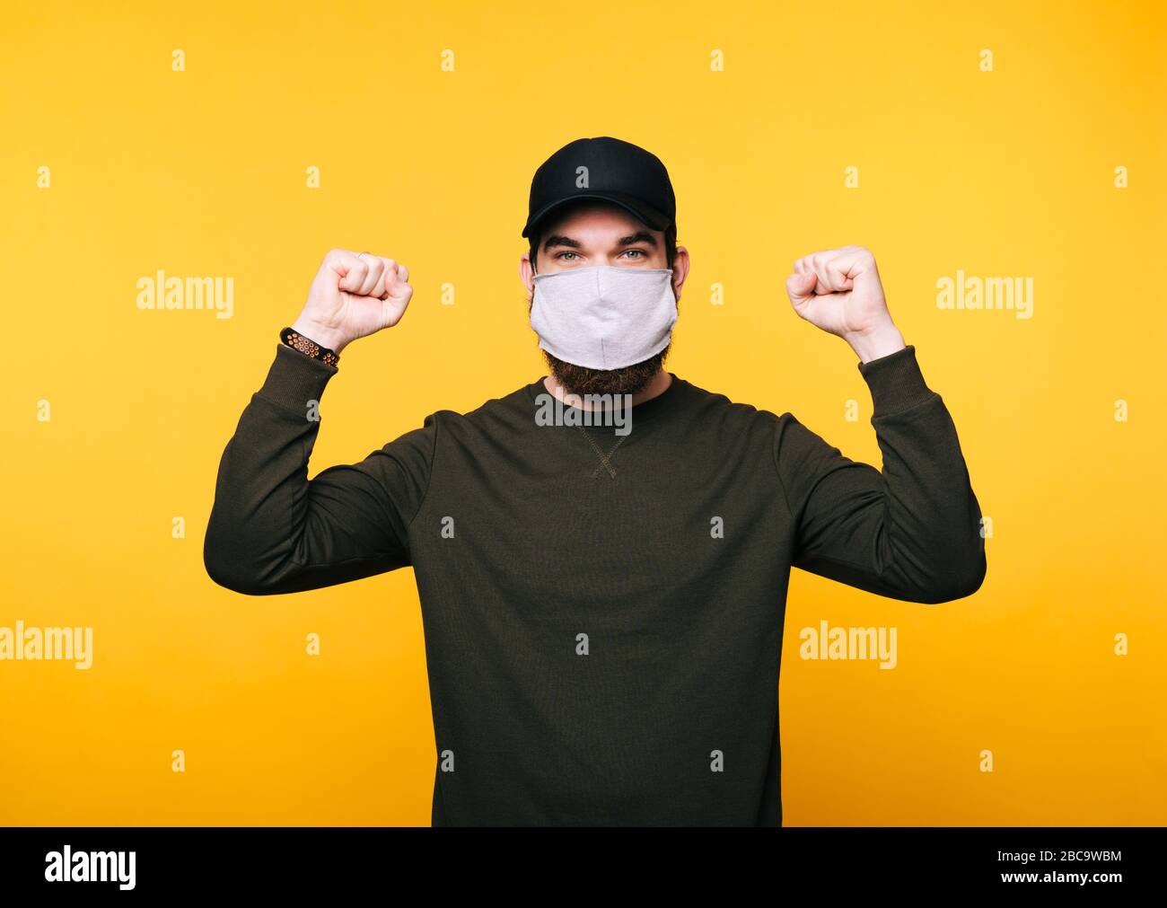 Download Portrait Of Young Man With Facial Mask Celebrating With Arms Up Over Yellow Background Stock Photo Alamy PSD Mockup Templates
