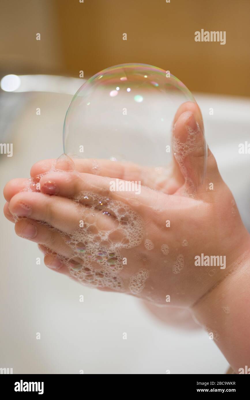 Close up of Young Boy Hand Holding Bubble Soap Stock Photo