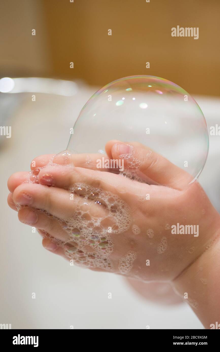 Close up of Young Boy Hand Holding Bubble Soap Stock Photo