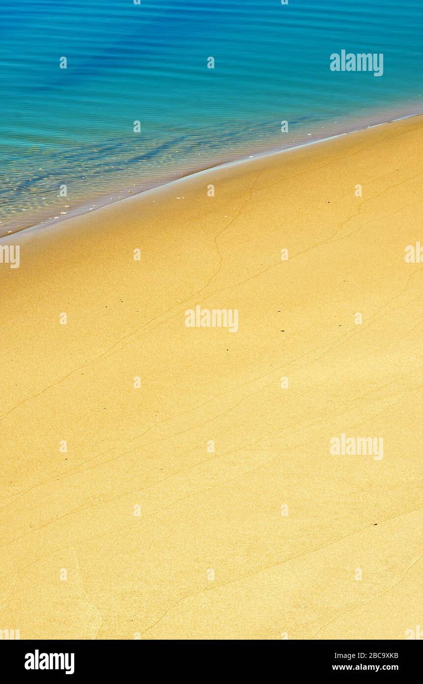 Serene sea shore closeup with calm water over sand Stock Photo