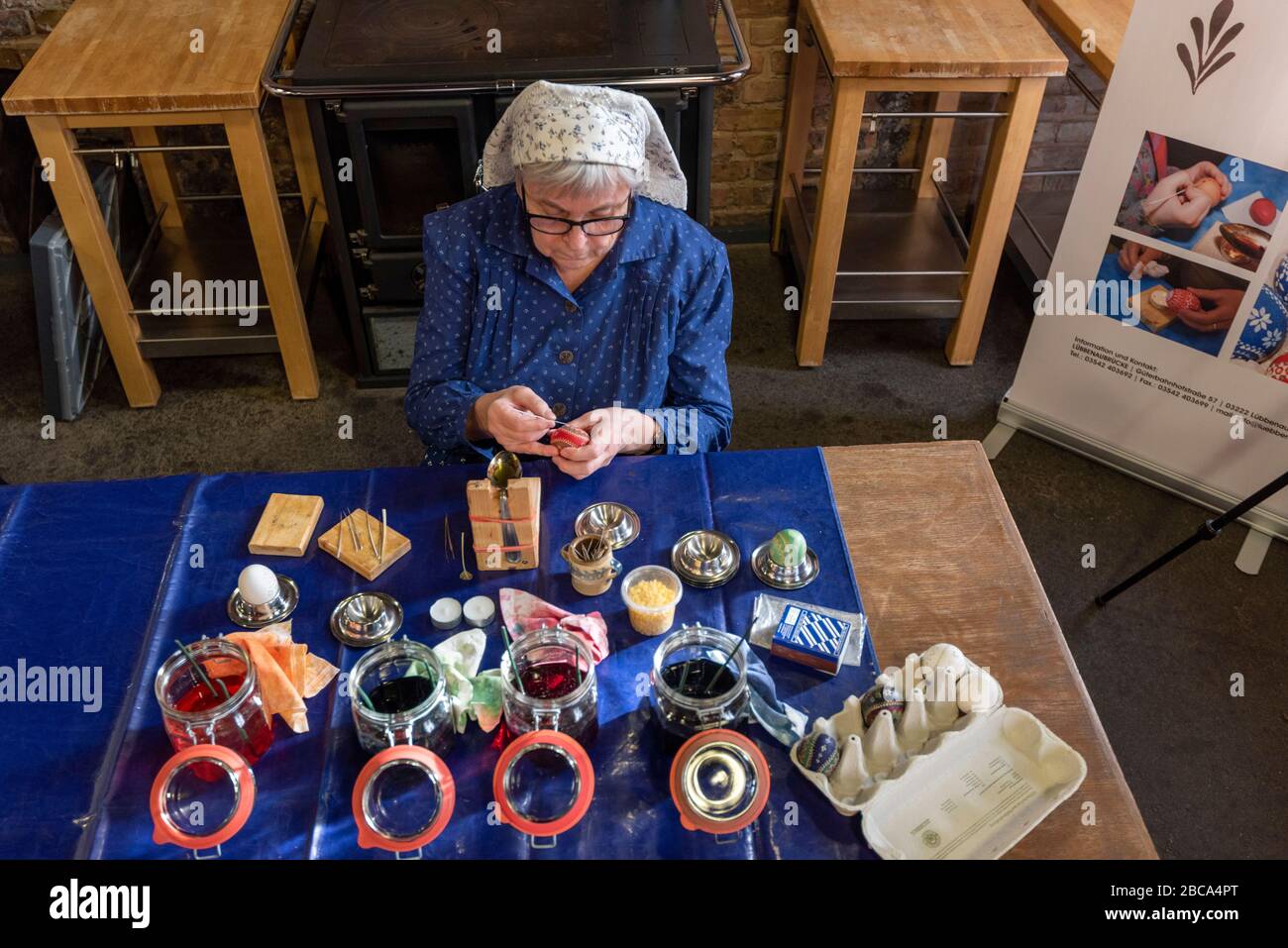 A woman in Sorbian dress decorates Easter eggs. Stock Photo