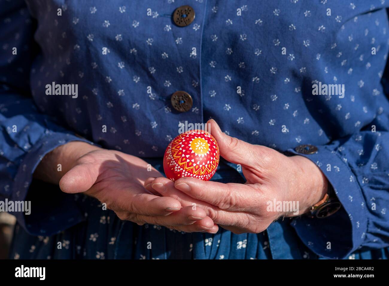A woman holds a Sorbian Easter egg in her hand. It was decorated with the wax batik technique. Stock Photo