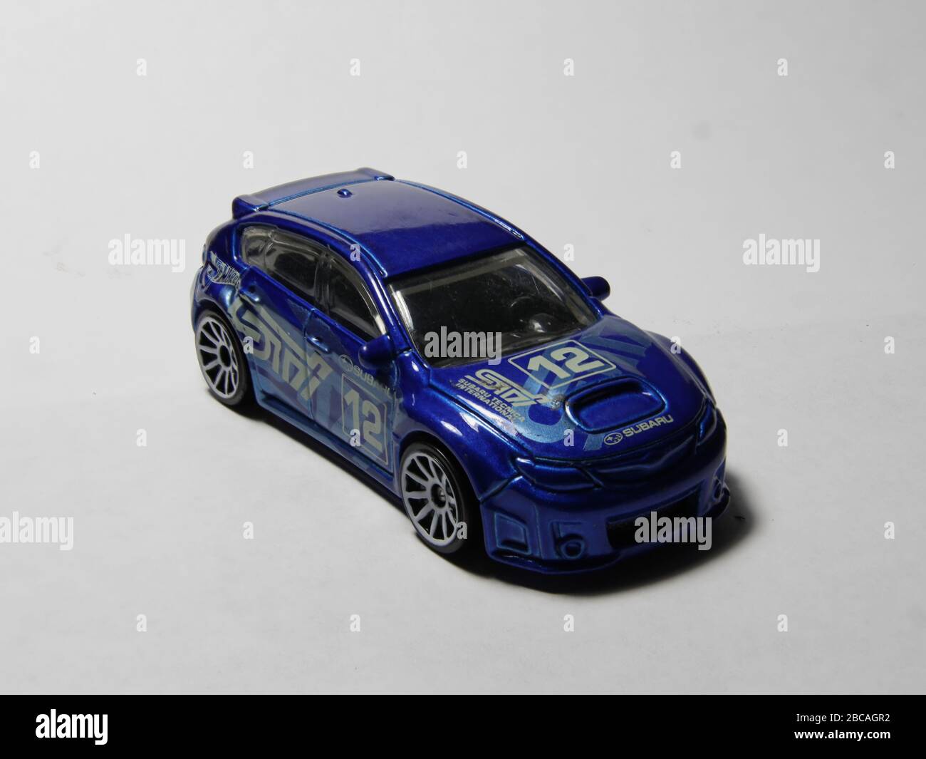 Subaru Rally car in rally blue. STI trim model rally spec wagon number 12. White wheels and traditional Subaru hood scoop. From four different angles. Stock Photo