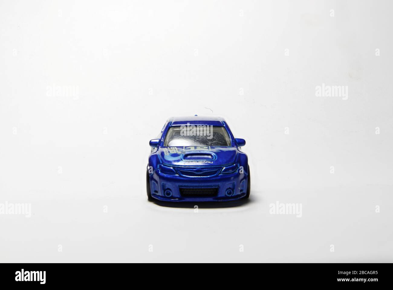 Subaru Rally car in rally blue. STI trim model rally spec wagon number 12. White wheels and traditional Subaru hood scoop. From four different angles. Stock Photo