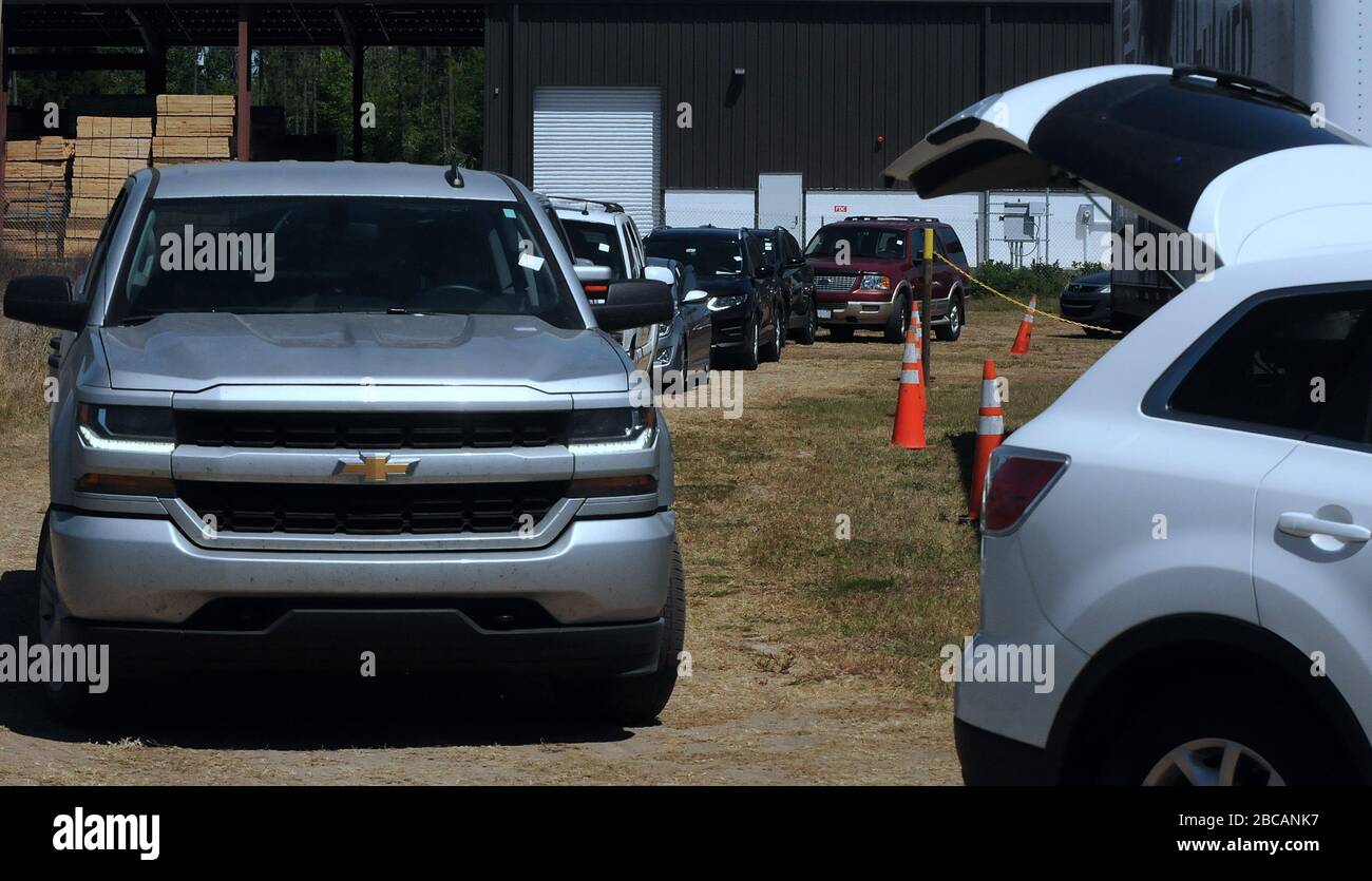 Groveland, United States. 03rd Apr, 2020. April 3, 2020 - Groveland, Florida, United States - A line of cars backs up as drivers wait to pick up food items from the Second Harvest Food Bank of Central Florida at a drive through event for needy families on April 3, 2020 at the Faith Neighborhood Center in Groveland, Florida, near Orlando. The coronavirus pandemic has put thousands of local service employees and theme park workers out of work, placing a strain on area food banks. Credit: Paul Hennessy/Alamy Live News Stock Photo