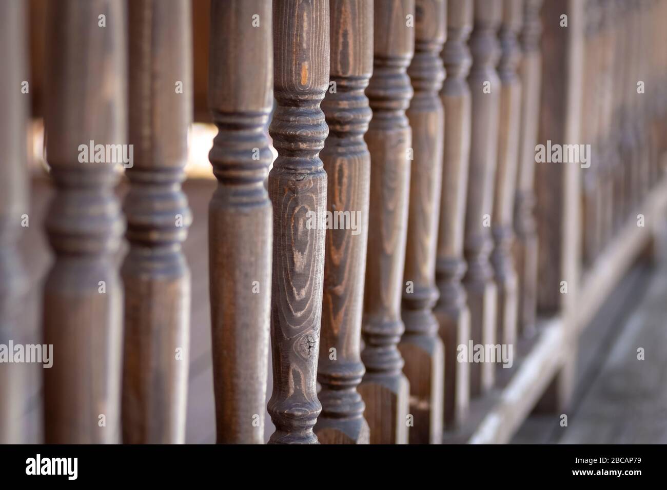 A row of balusters of a wooden veranda. Stock Photo