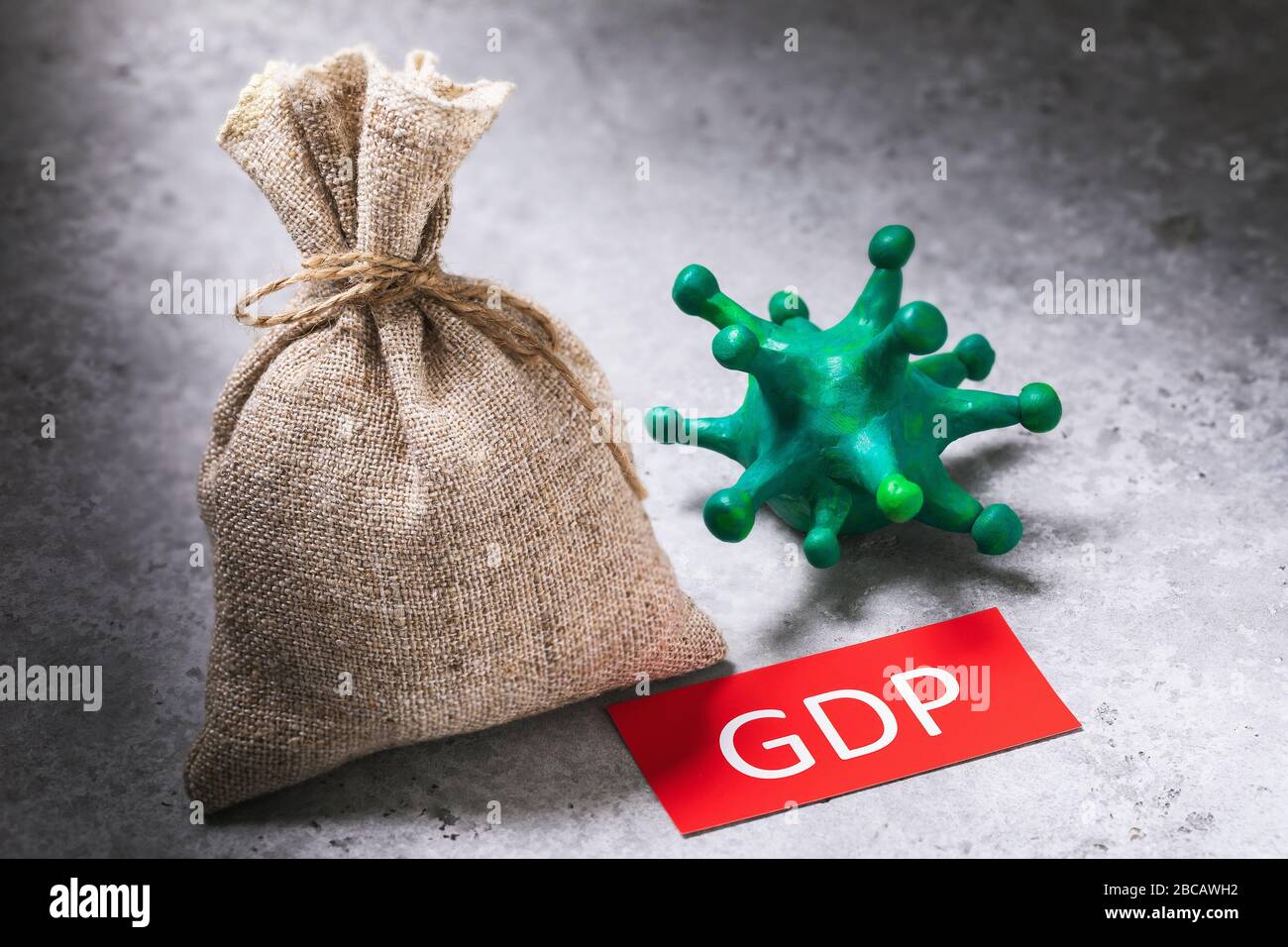 Toy coronavirus, tag with text and a full bag. The concept of the impact of the covid-19 pandemic on country GDP Stock Photo