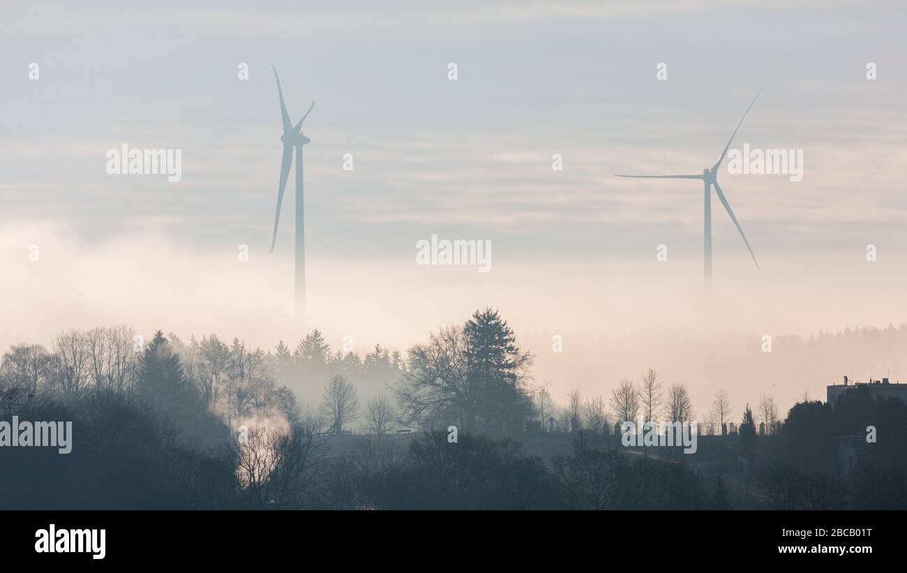 Silhouette of two wind turbines at dusk. Located close to Lake Starnberg (Starnberger See). Producing energy for bavarian households. Panorama format. Stock Photo