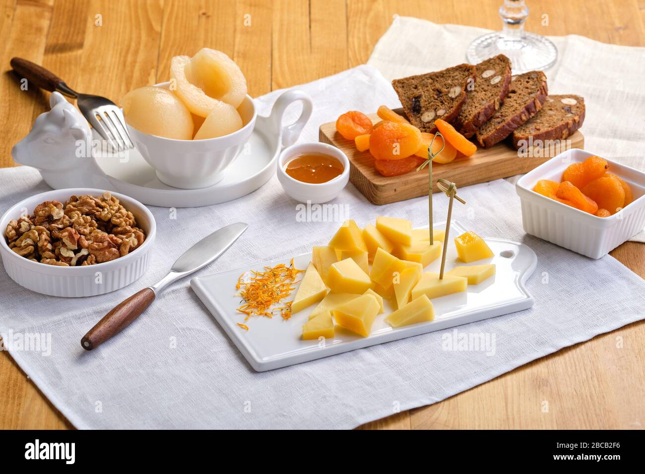 Set of various appetizers for wine - cheese, walnuts, dried apricots, honey and canned pear Stock Photo