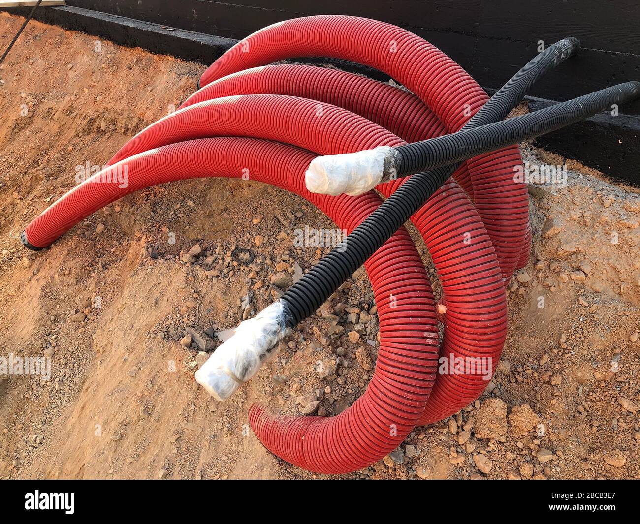 coiled corrugated pipes and high voltage cables. Stock Photo