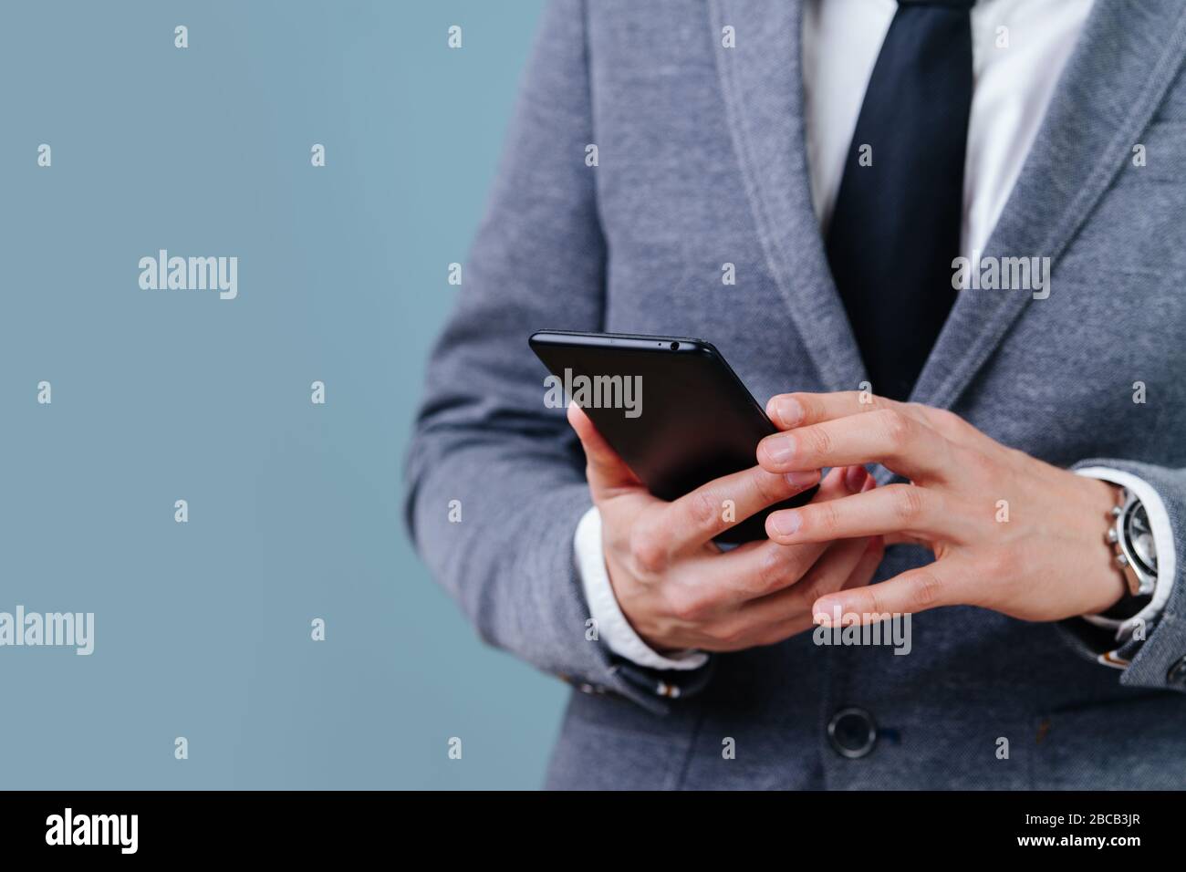 A man in a suit holds a phone Stock Photo