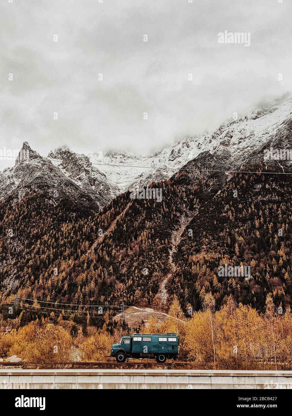dark green truck against an autumnal mountain backdrop Stock Photo