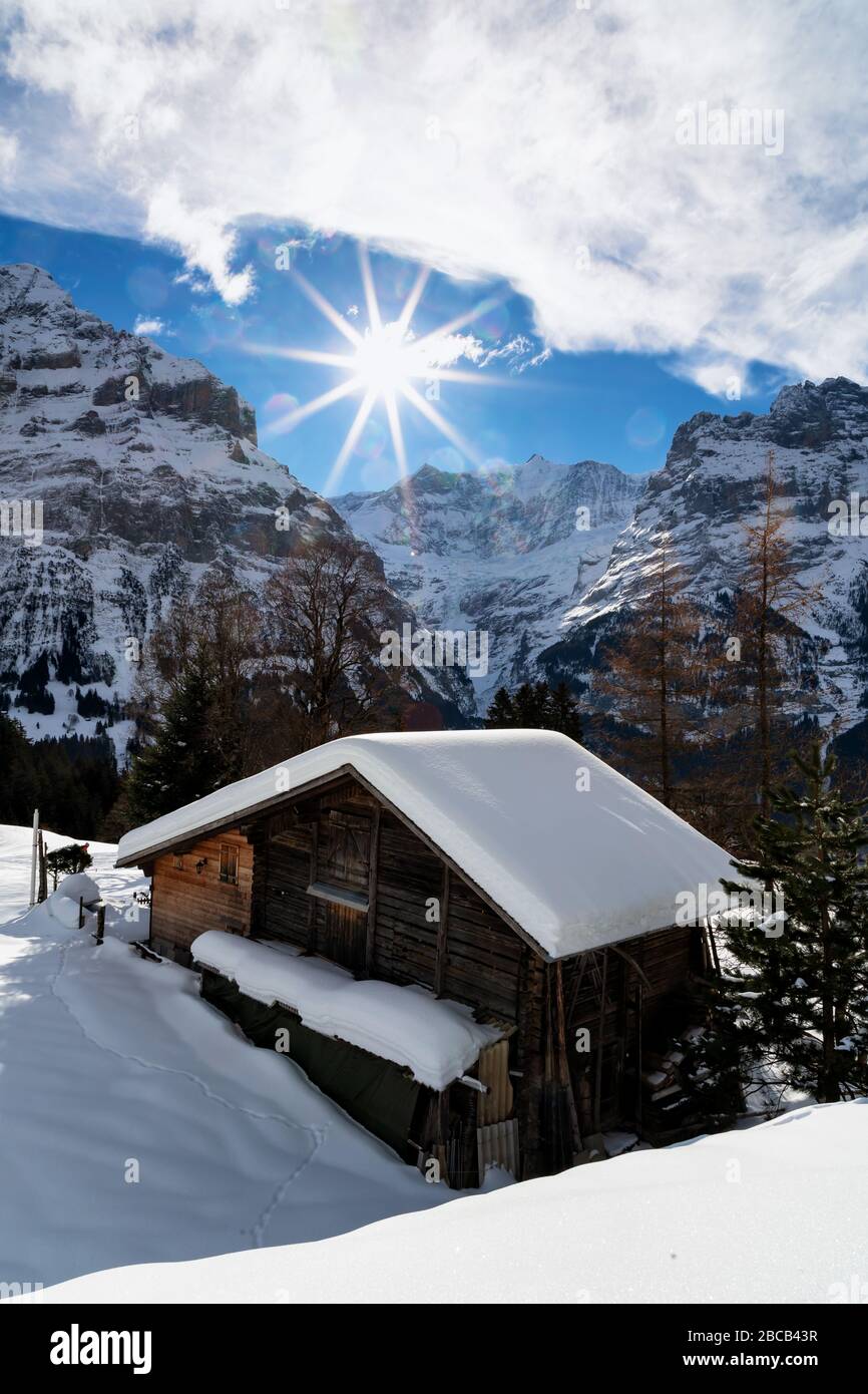 An alpine hut lies deep in snow in the mountains above Grindwald in the Bernese Alps. Stock Photo
