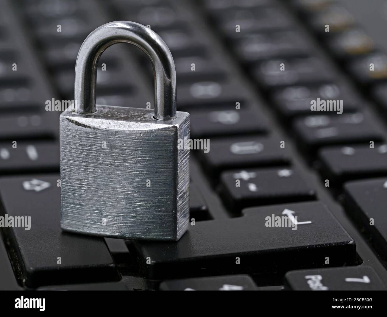 silver padlock on black computer keyboard, close up Stock Photo