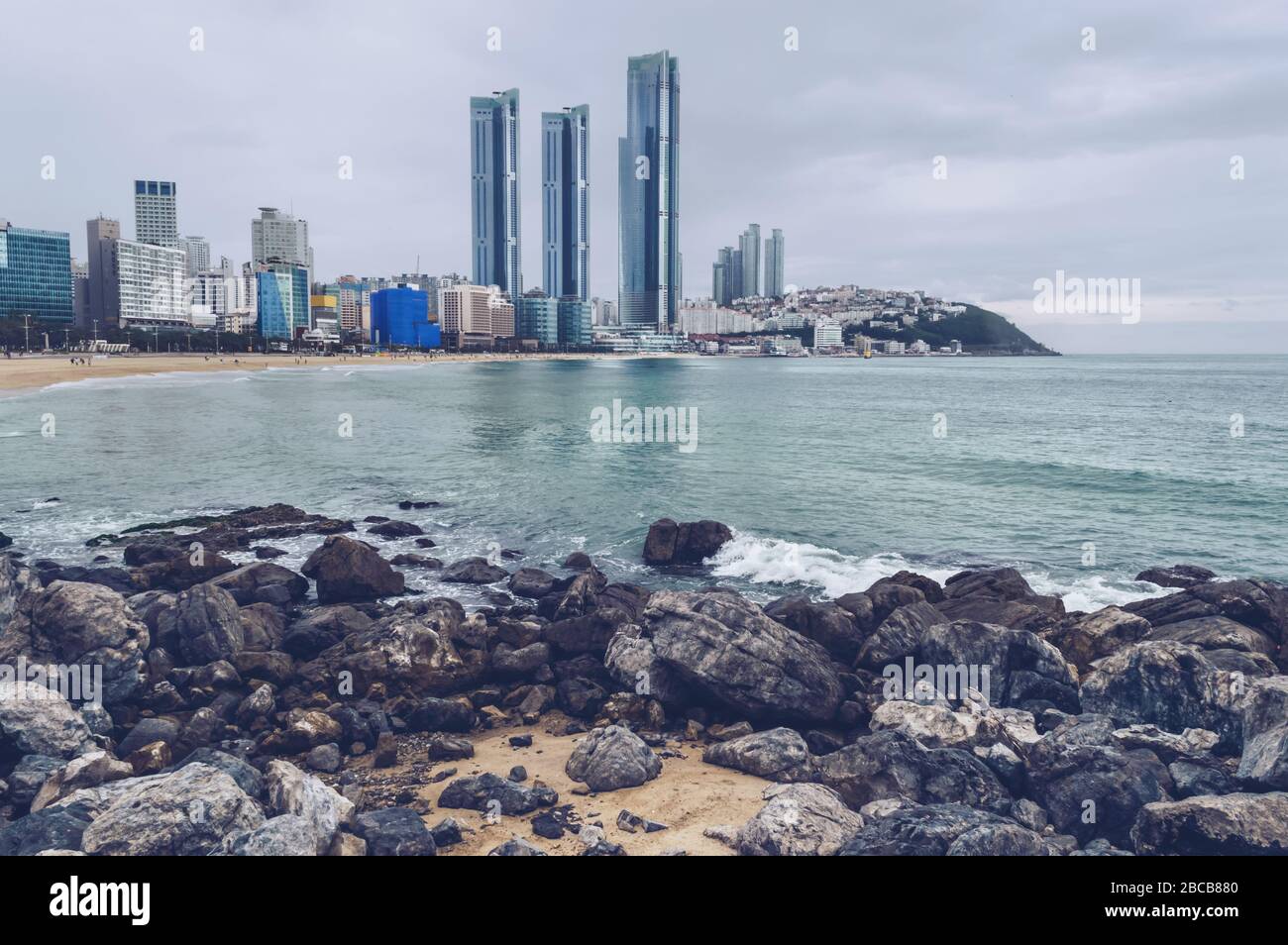 boulders on the Haeundae beach in Busan on gloomy day with cityscape view Stock Photo