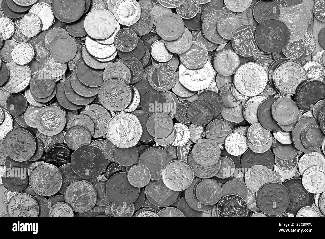 UK currency, hundreds of British copper and silver colored coins randomly piled ontop of each other, one pound coins, fifty pence, twenty pence, two p Stock Photo