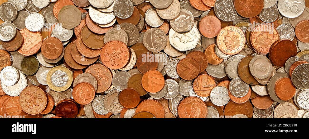 UK currency, hundreds of British copper and silver colored coins randomly piled ontop of each other, one pound coins, fifty pence, twenty pence, two p Stock Photo