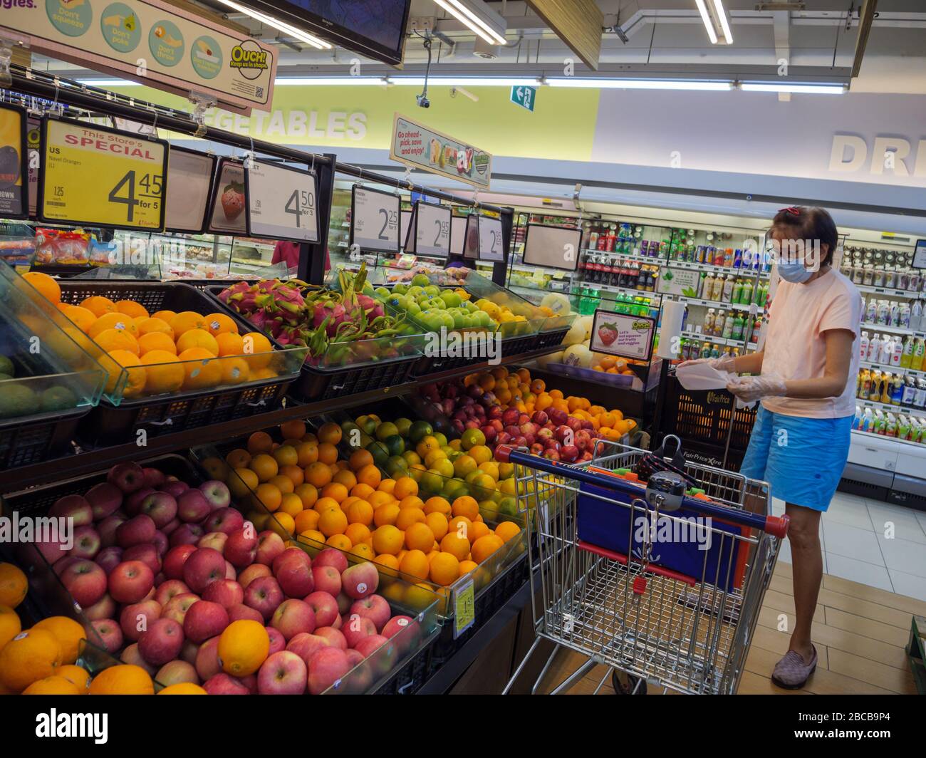 SINGAPORE 2 APR 2020 Middle aged woman wearing surgical mask shops