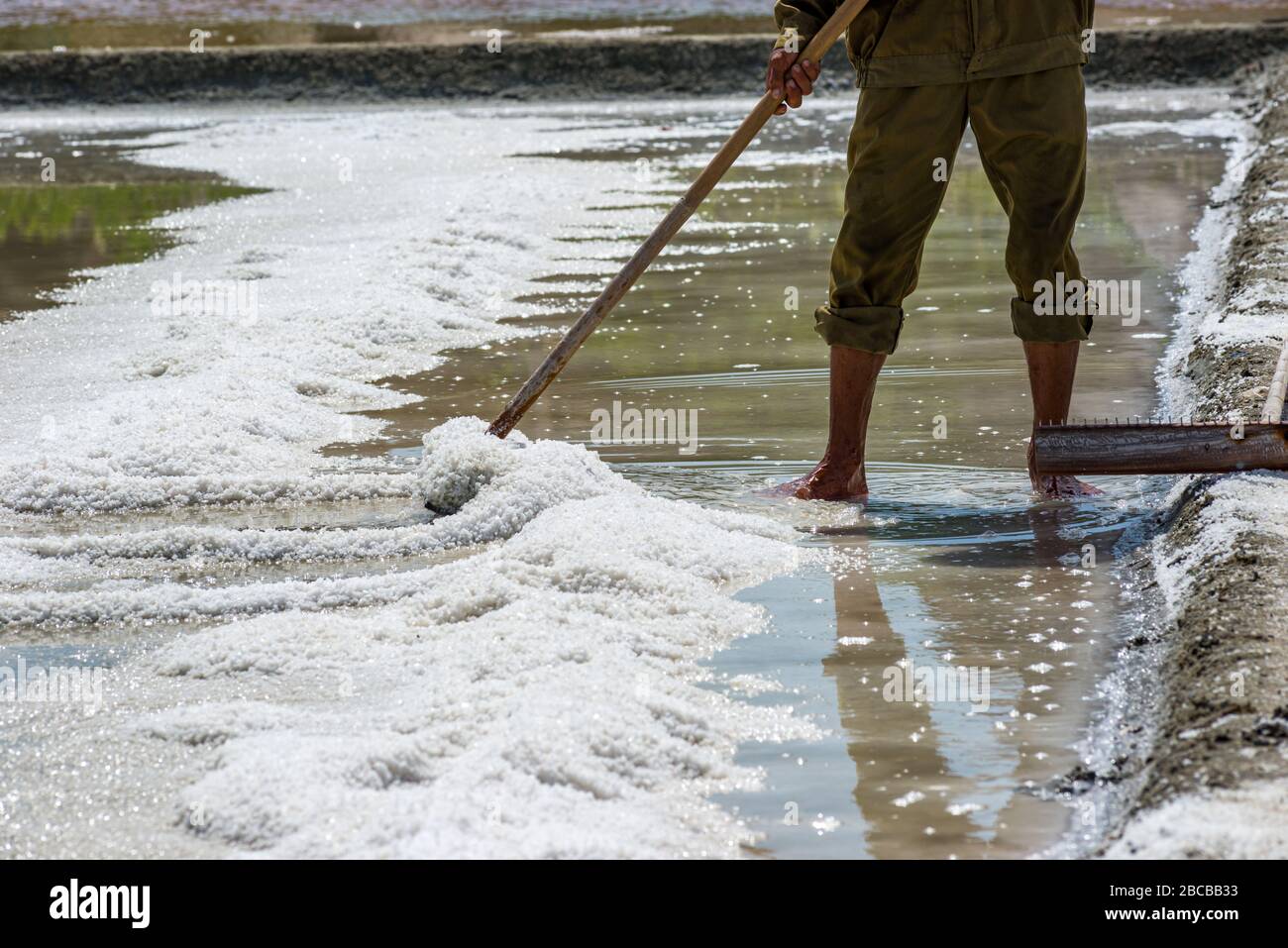 Farmer working on sea salt farm in Phan Rang, Vietnam Stock Photo