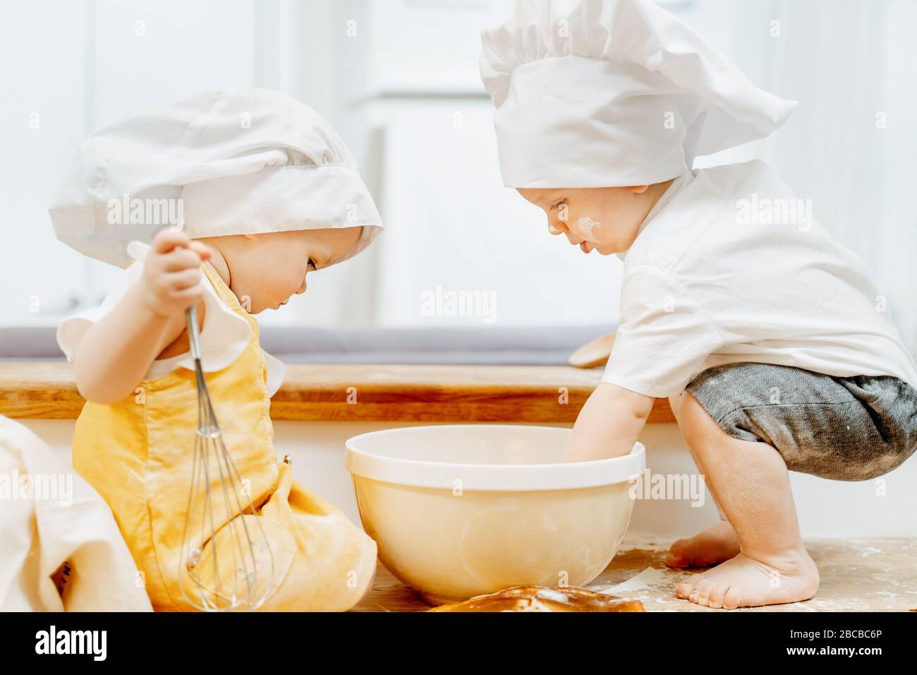 Side view of a cute little cook children in hats Stock Photo