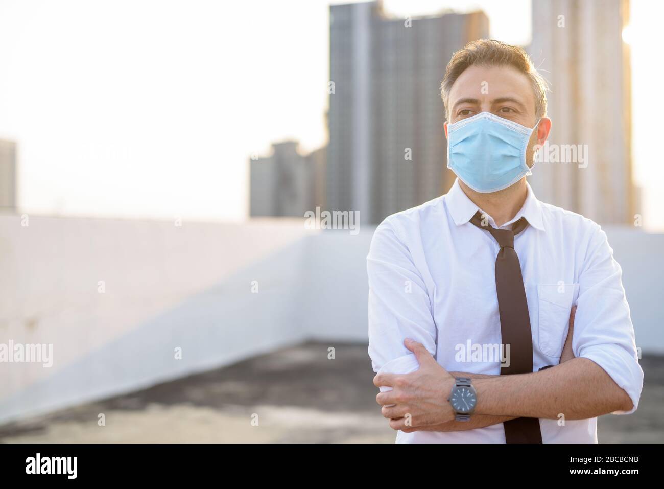Mature businessman wearing mask for protection from corona virus outbreak and pollution Stock Photo
