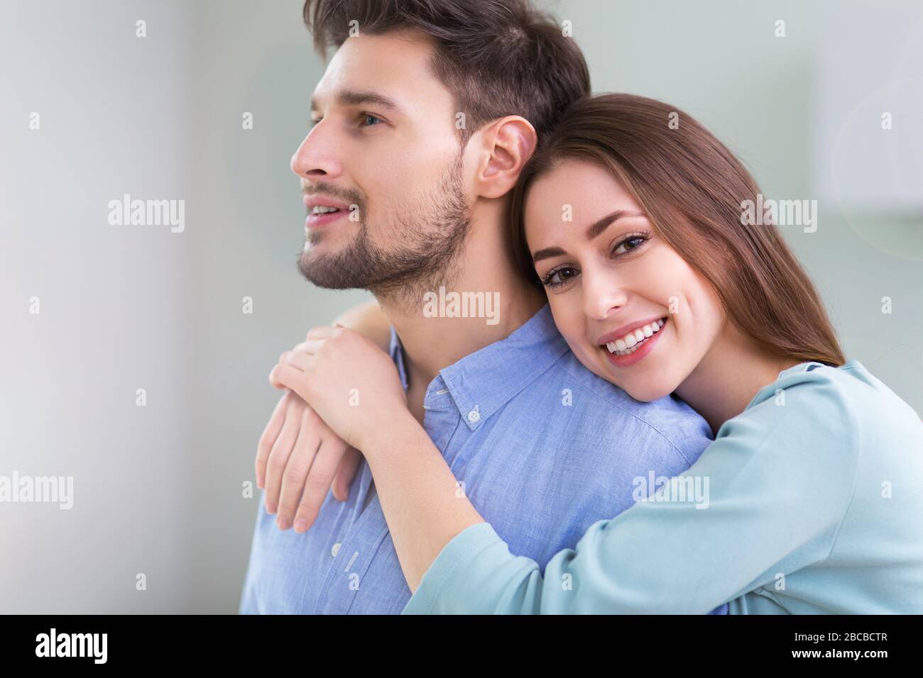Young couple hugging at home Stock Photo - Alamy