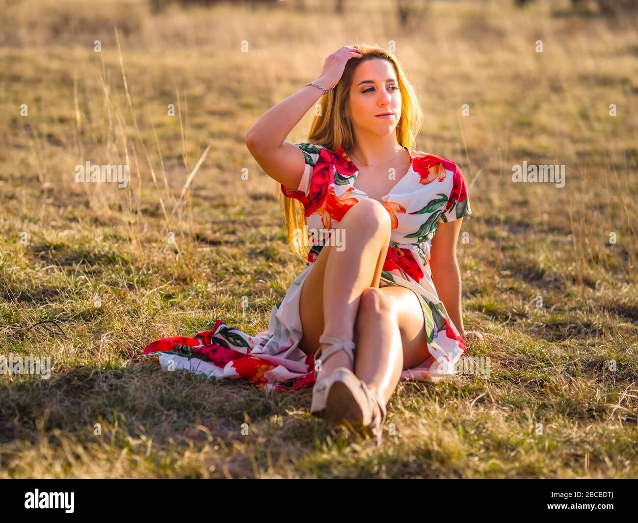 Teenage female person aka young woman sitting on grass-field looking ...