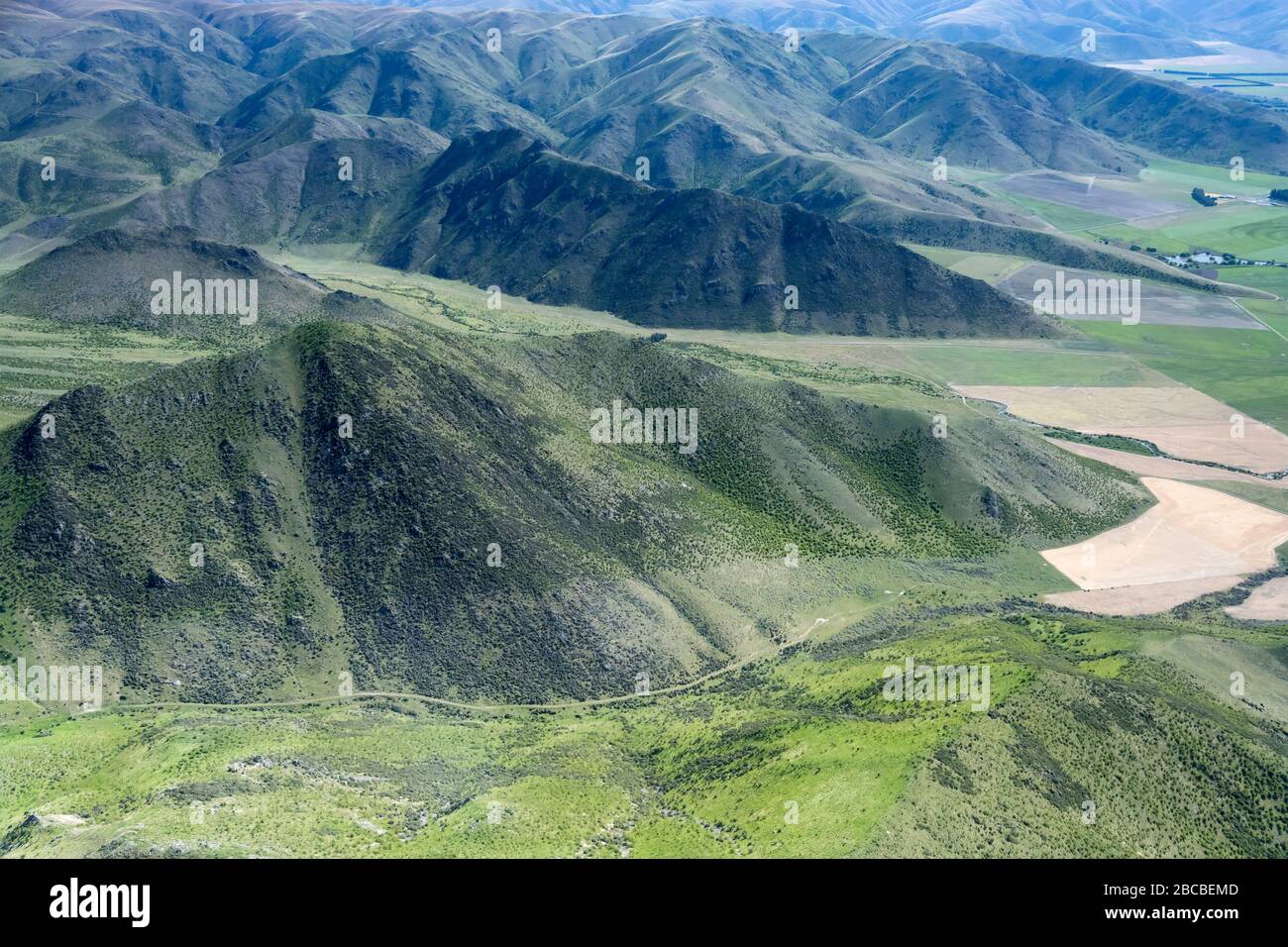 aerial, from a glider, of dirt road in little valley among Benmore Peak ...