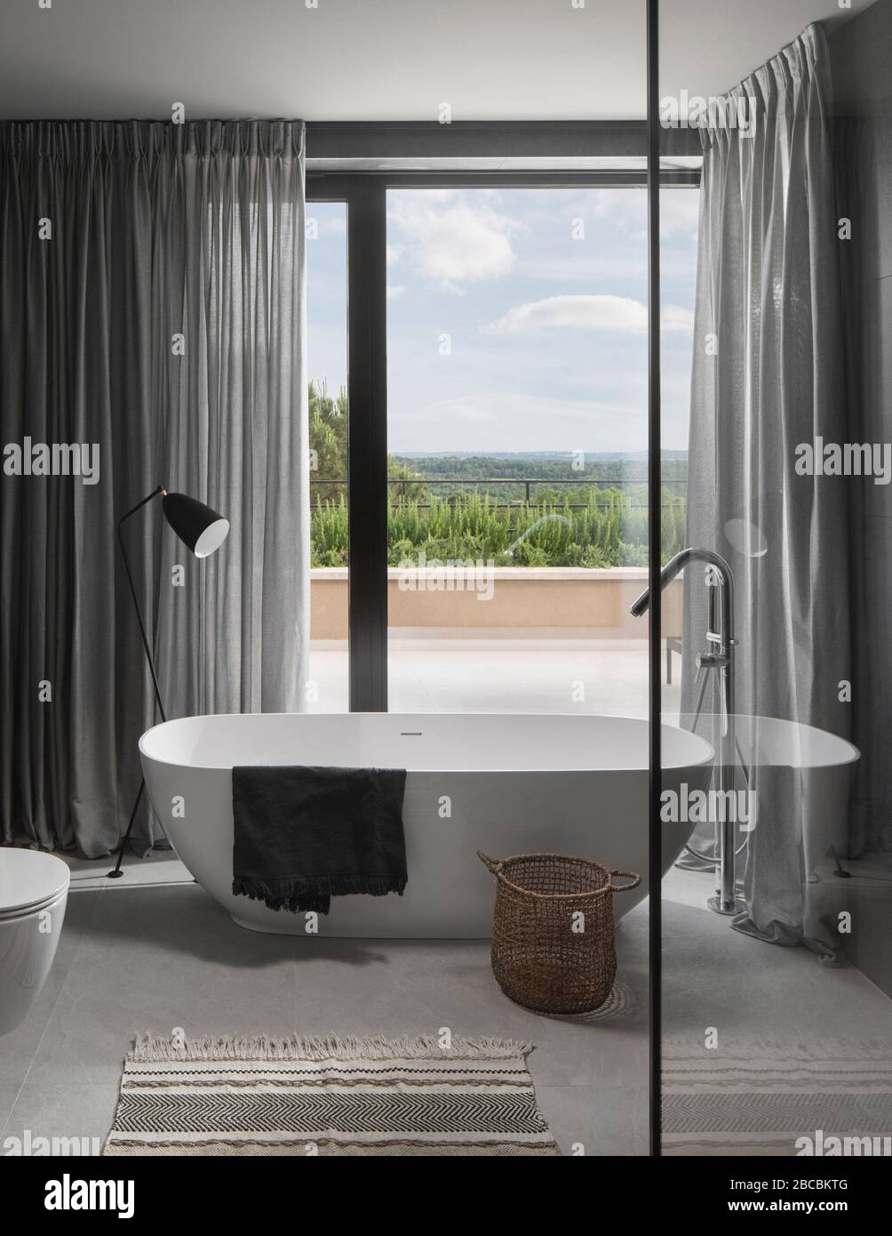 Modern elegant freestanding bath with landscape view. Stock Photo