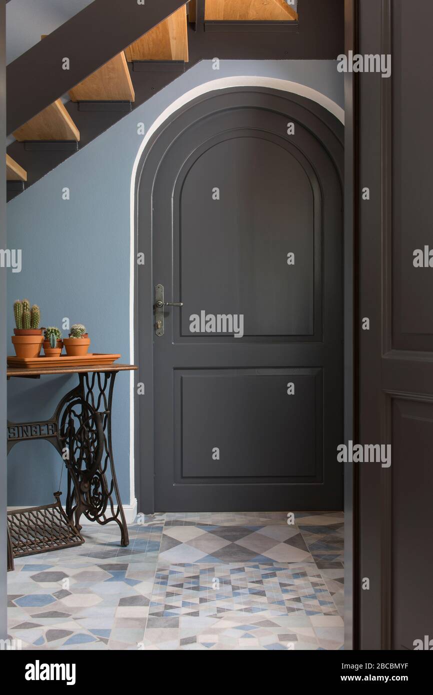 Traditional mediterranean house detail with blue wall and old Singer machine by the arched door. Stock Photo