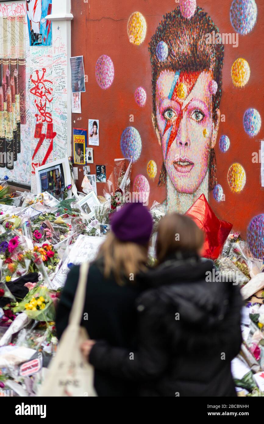 Mural of David Bowie in Brixton surround by memorial offerings laid just after his death, London Stock Photo
