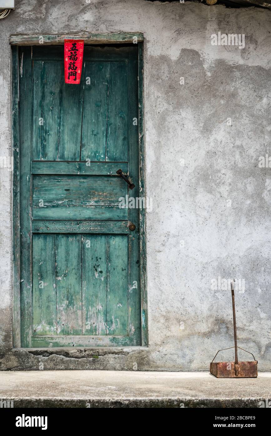 Yangshuo, China August 2019 Closed shut green wooden doors to the