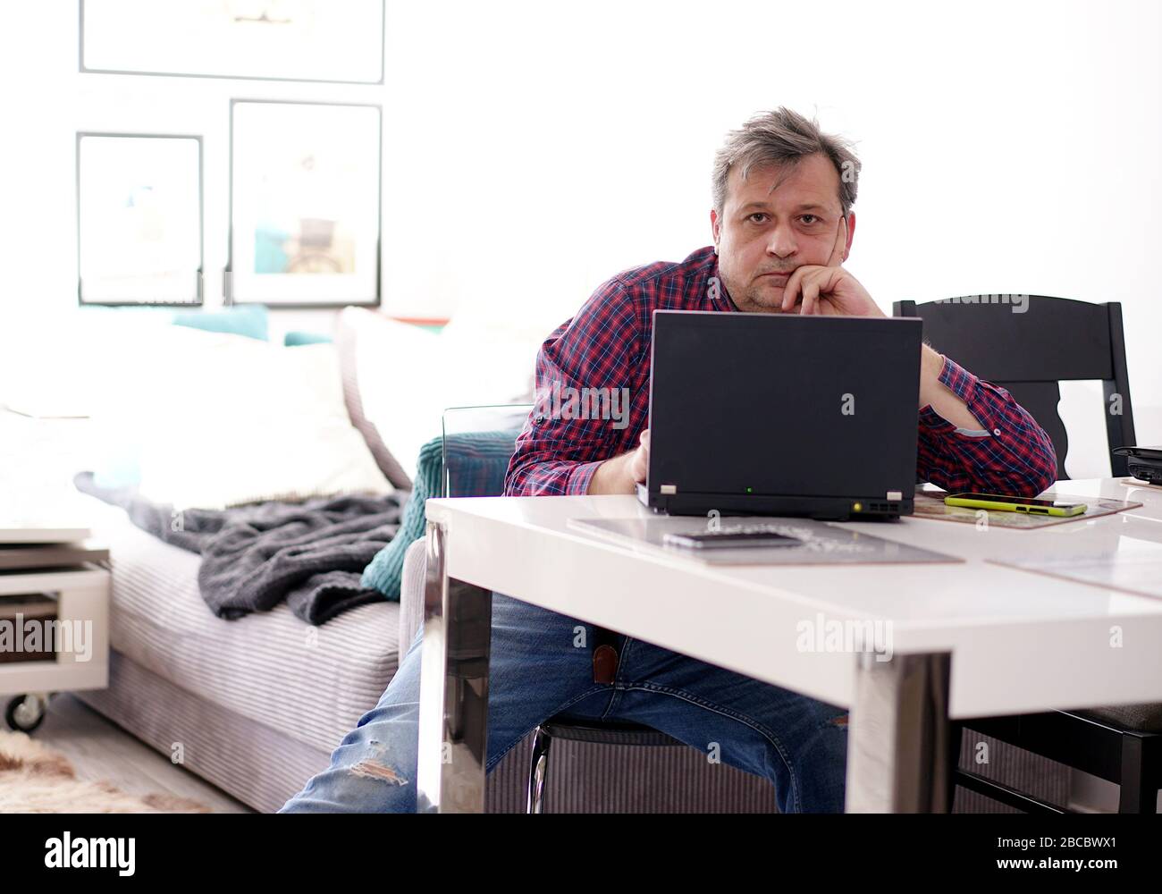 middle-aged man working remotely at home office Stock Photo