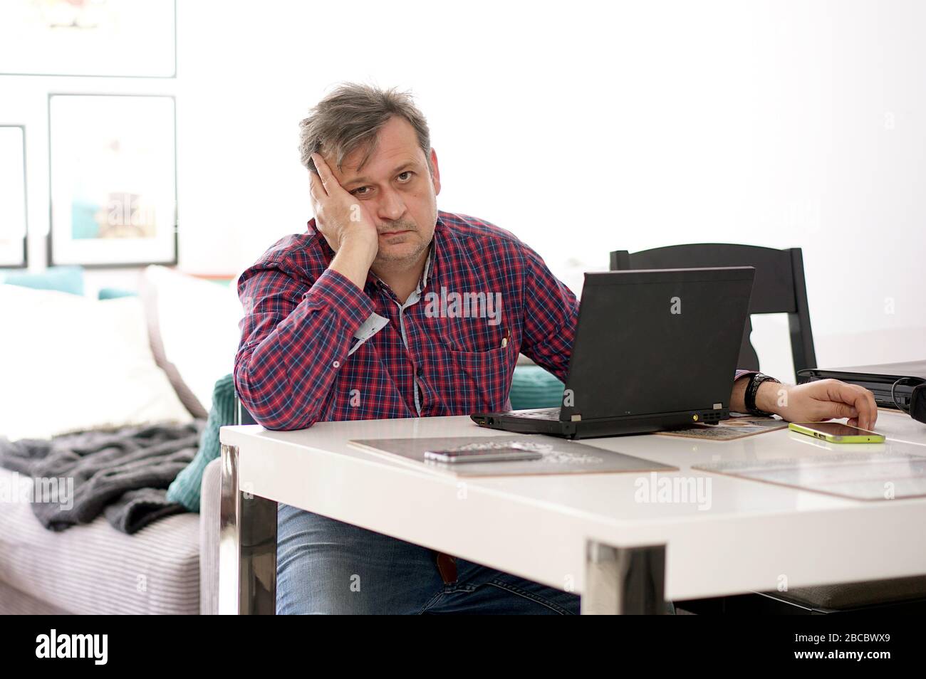 middle-aged man working remotely at home office Stock Photo