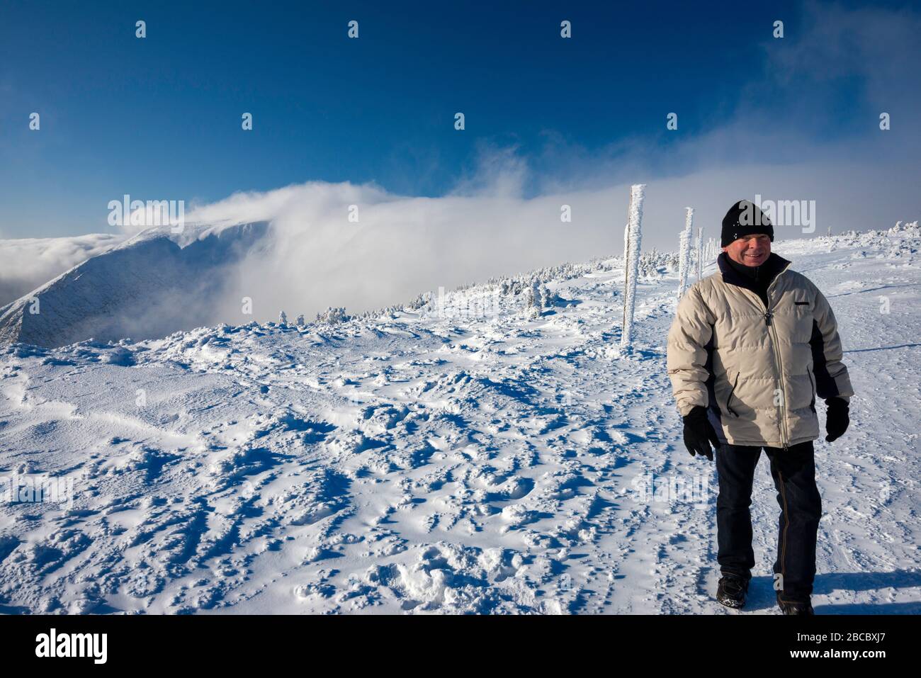 Man in his sixties hiking in Karkonosze (Krkonose) in winter, foehn cloud, Sudetes mountain range, Karkonosze National Park, Lower Silesia, Poland Stock Photo