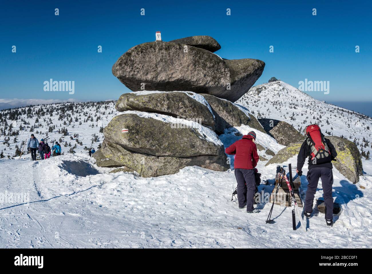 Hikers at rock formation Twaroznik, Polish–Czech border marker on top, subalpine plateau, main ridge in Karkonosze National Park, Lower Silesia Poland Stock Photo