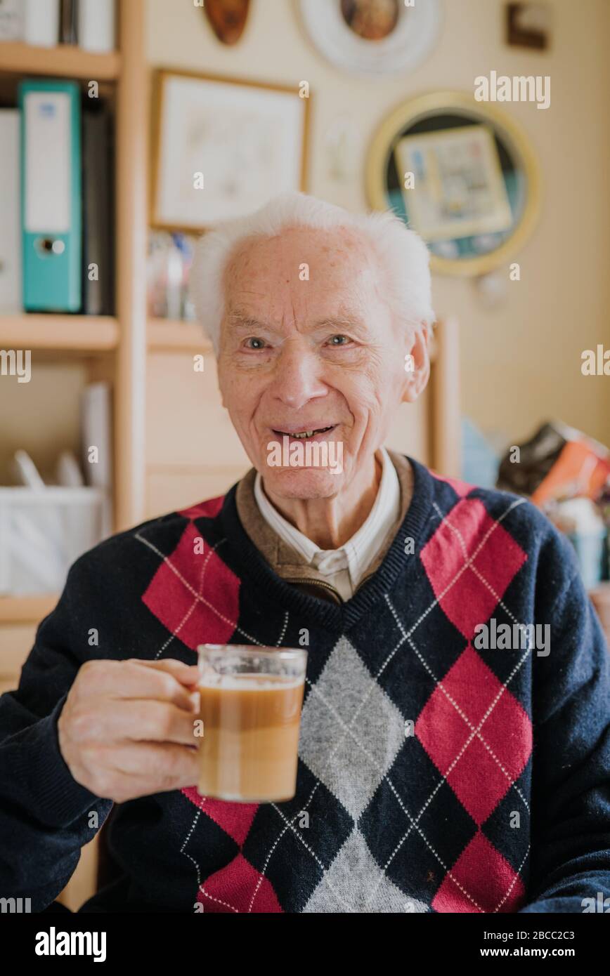 Positice senior drinking coffee at home Stock Photo