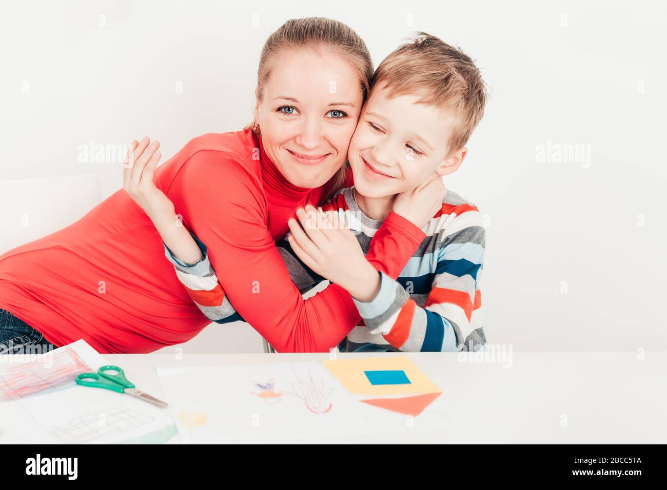 Son holding and kising his mom on white background Stock Photo - Alamy