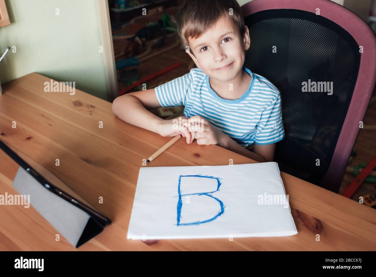 Happy child shows page with written letter B, home schooling Stock Photo