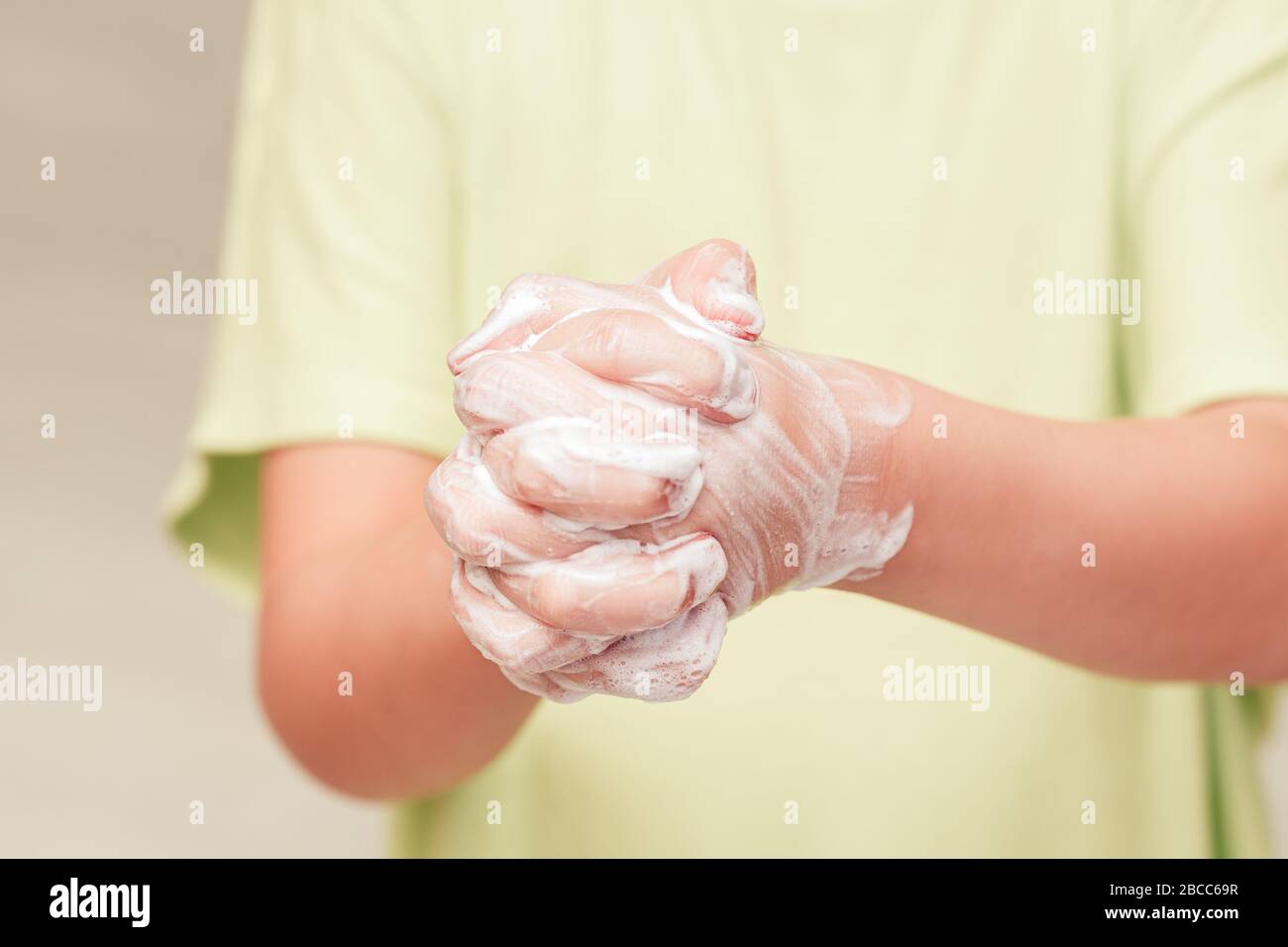 Small child washing hands with soap, close up. Importance of personal