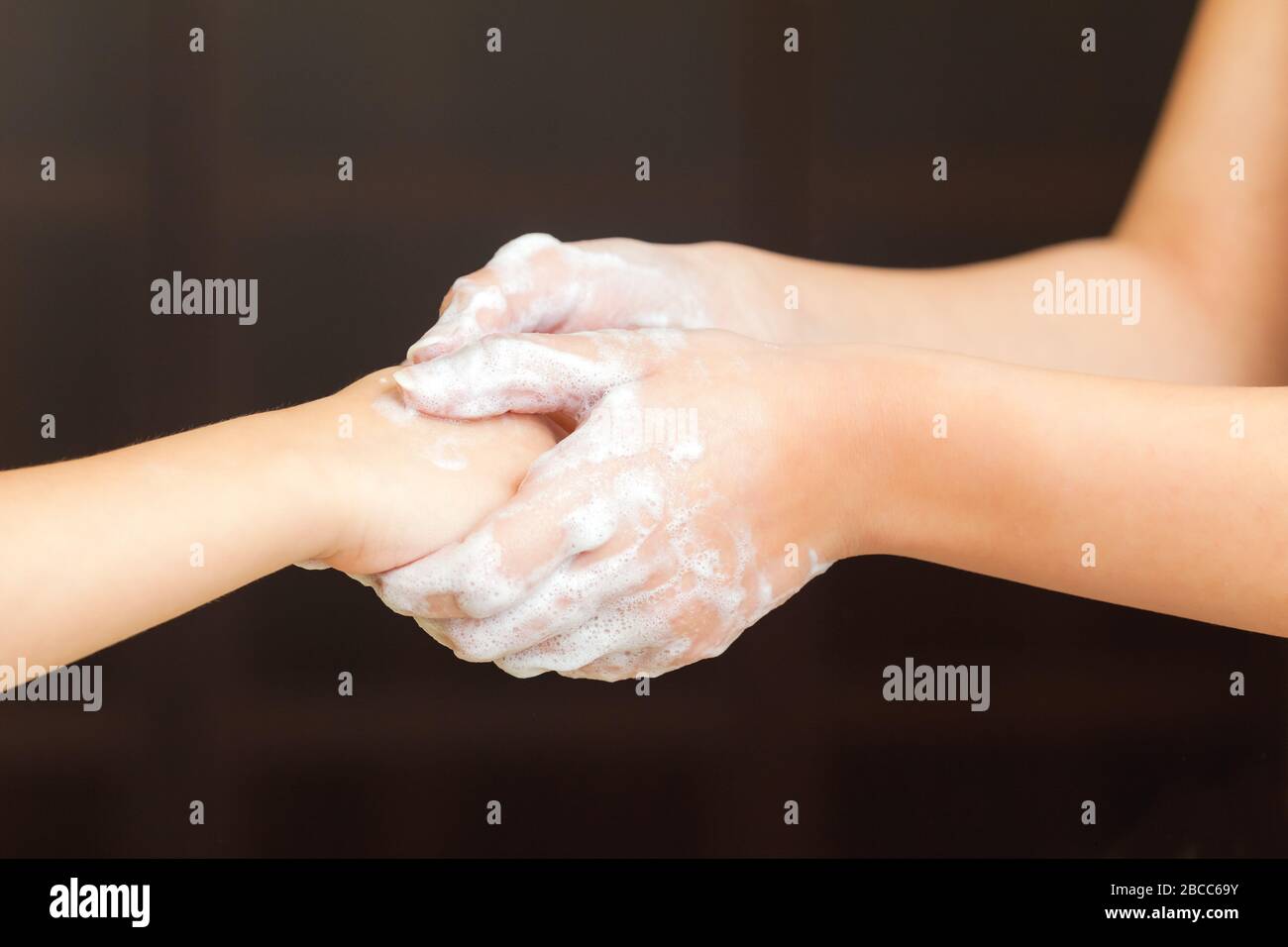 Adult teaching kid washing hands for prevent Illness and keep himself healthy Stock Photo