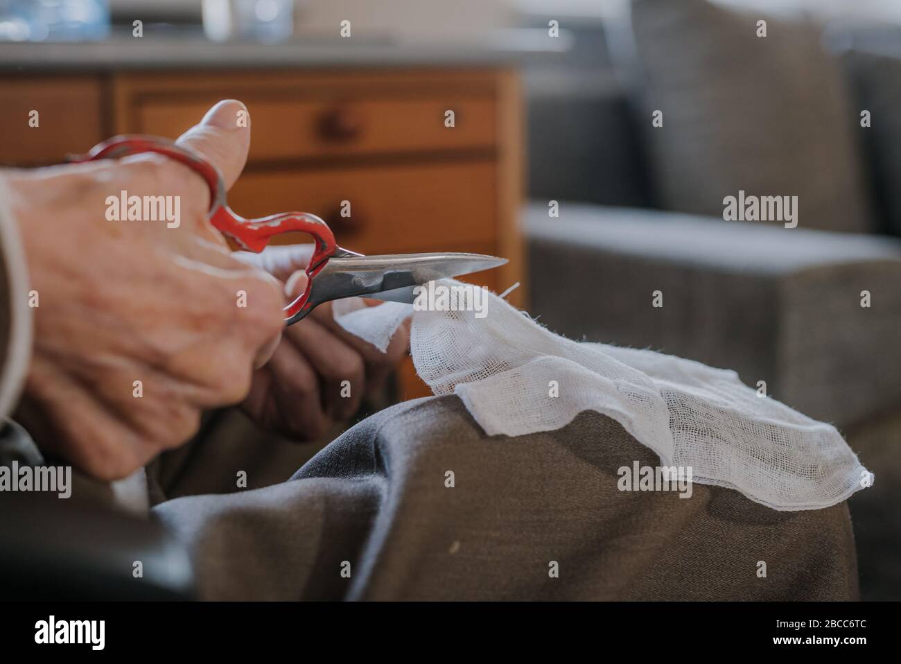 Old man preparing bandage, cuts gauze with scissors Stock Photo Alamy