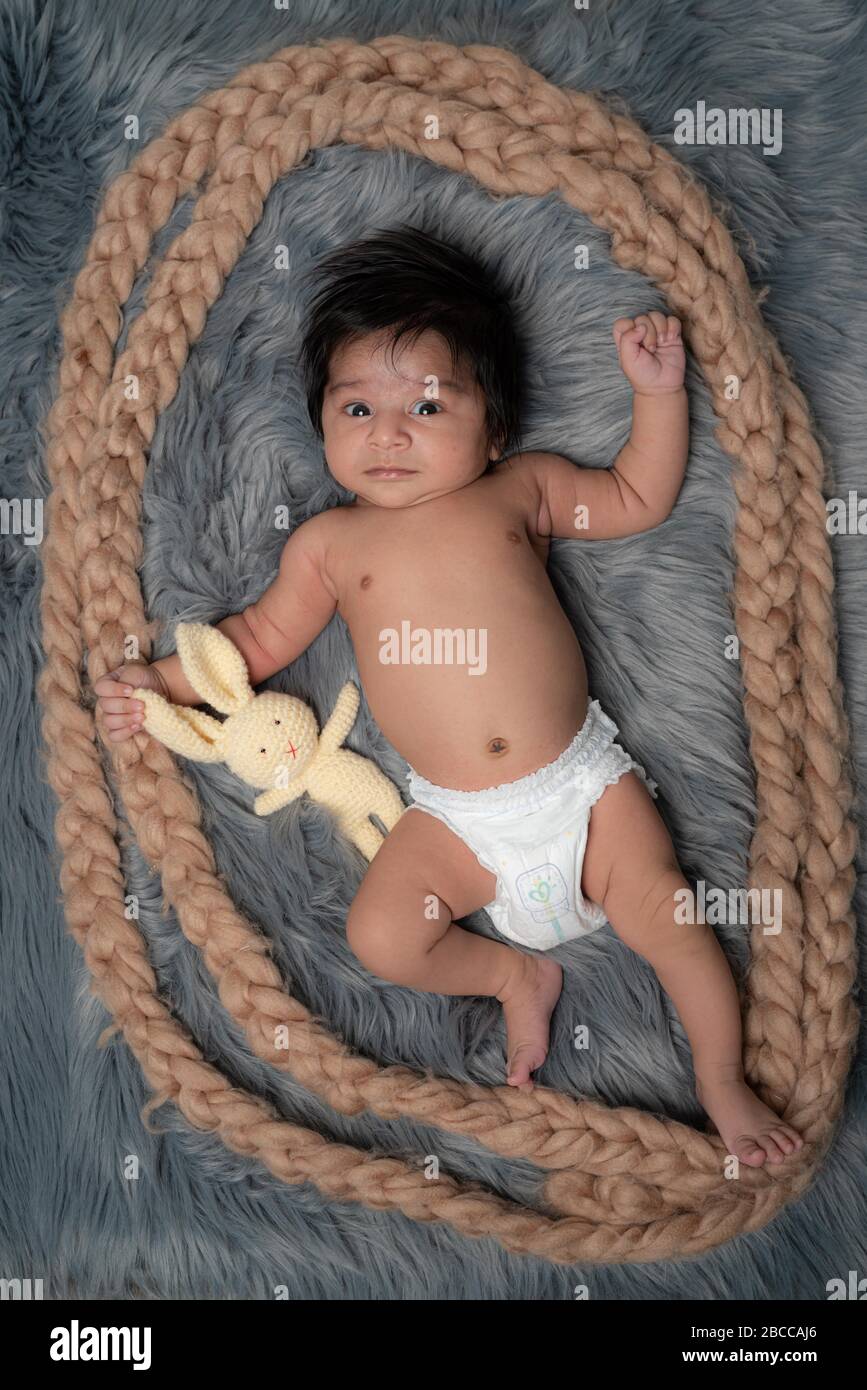 My Best Friend the baby sleeping with her teddy bear on grey fur bed sheet, New family and baby healthy concept Stock Photo