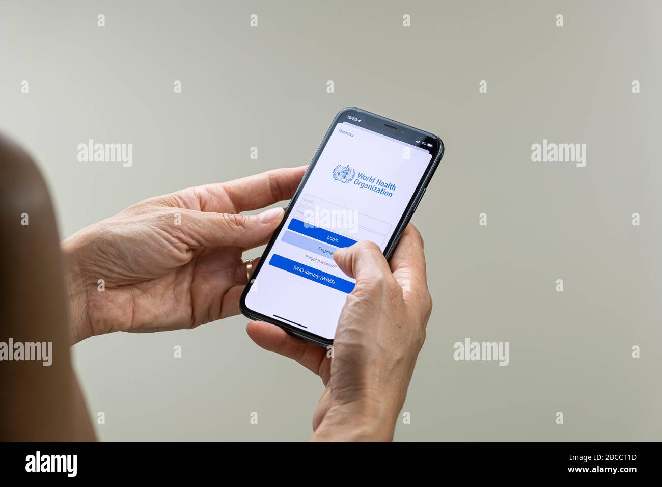 Woman registering on the World Health Organization application on her smartphone Stock Photo