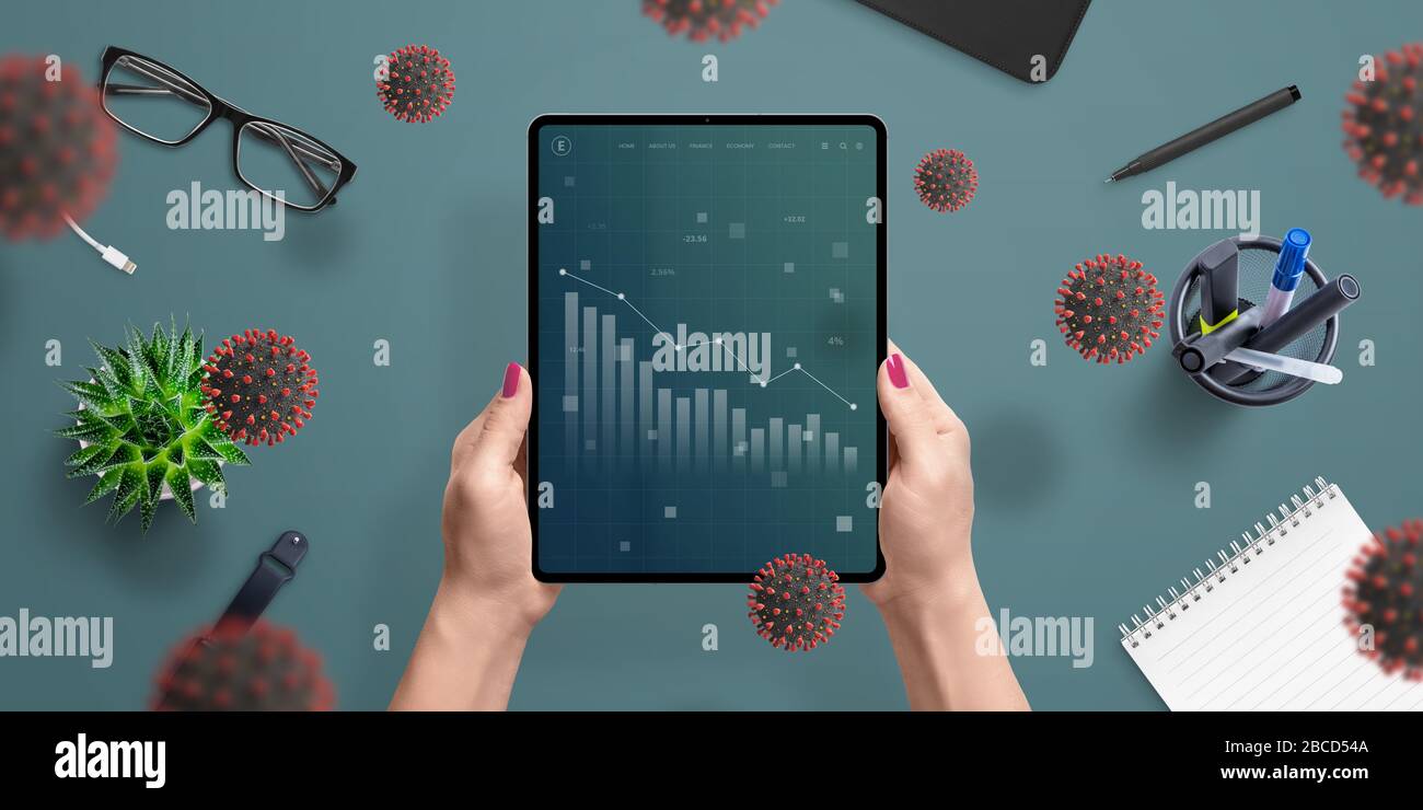 Charts concept of the coronavirus impact on the global economy and markets on tablet screen in woman hand. Top view, flat lay composition Stock Photo